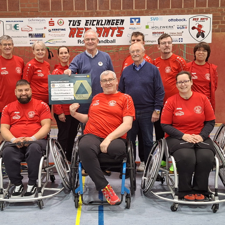Andreas Dietterle (im Rollstuhl) wird der Scheck überreicht. Hartmut Krause ist hinten links im Bild zu sehen