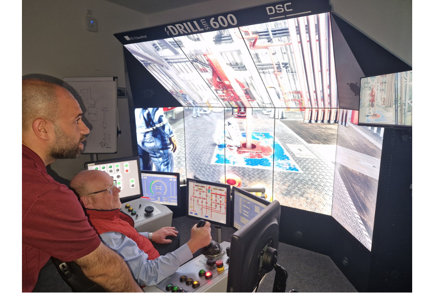 Lions Club Präsident versucht sich am Drilling Simulator als Bohrmeister unter Anleitung eines wissenschaftlichen Mitarbeiters