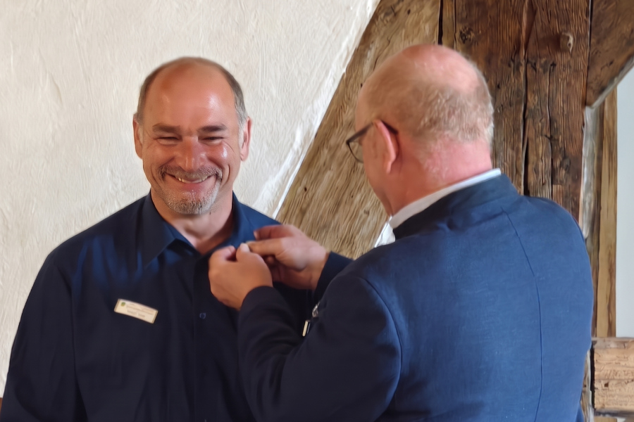 Tobias Sieg erhält von Hermann Baars die Präsidenten-Anstecknadel